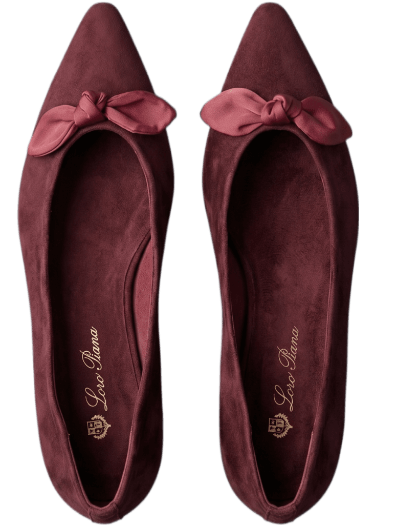 Top view of a pair of burgundy suede pointed-toe ballet flats with decorative bows, Shoeaholic Bahrain Footwear.| منظر علوي لزوج من أحذية الباليه المسطحة من الشامواه العنابي مع فيونكة زينة، شوهوليك البحرين للأحذية.